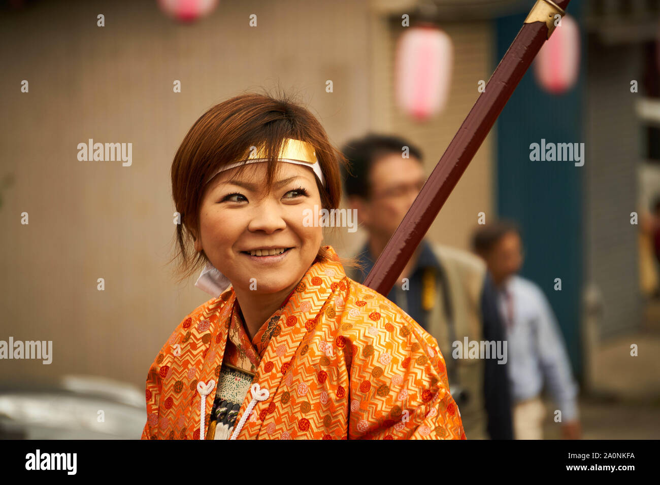 Lächelnd japanischen Frau reenactor in traditionelle Samurai Kostüm und Rüstungen (Armor) Märsche mit Gewehr an Samurai Festival gekleidet; Sarugakyo, Japan. Stockfoto