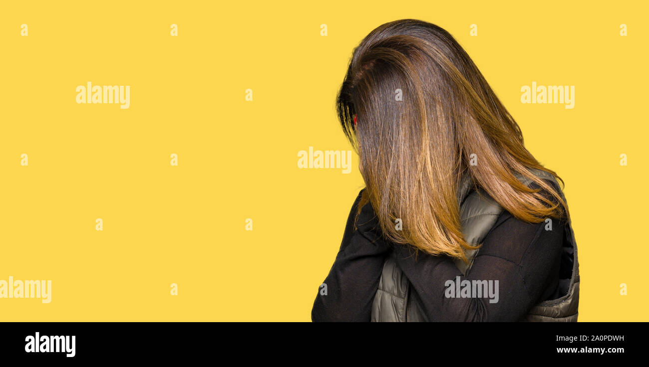 Schöne Frau mittleren Alters tragen winter Weste mit traurigen Gesichtsausdruck das Gesicht mit den Händen und weinte. Depression Konzept. Stockfoto