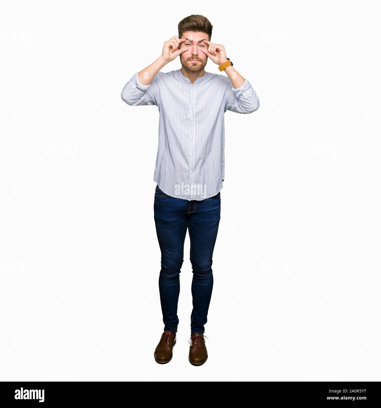 Jungen gutaussehenden Mann, der versucht, die Augen mit den Fingern, schläfrig und müde für morgendliche Müdigkeit zu öffnen. Stockfoto