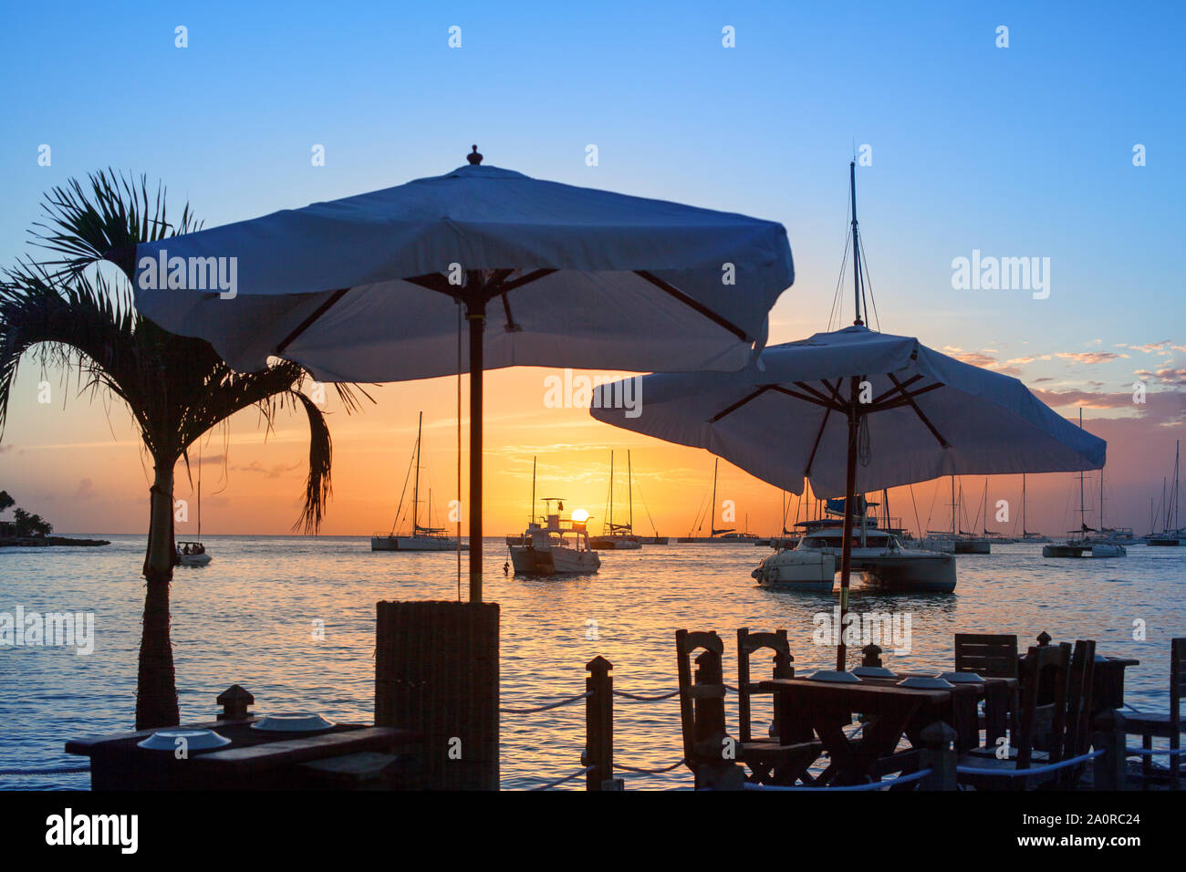 Schönen Sonnenuntergang auf dem Meer Strand Cafe oder Restaurant, Boote, Schiffe und Yachten auf dem Wasser Hintergrund Stockfoto