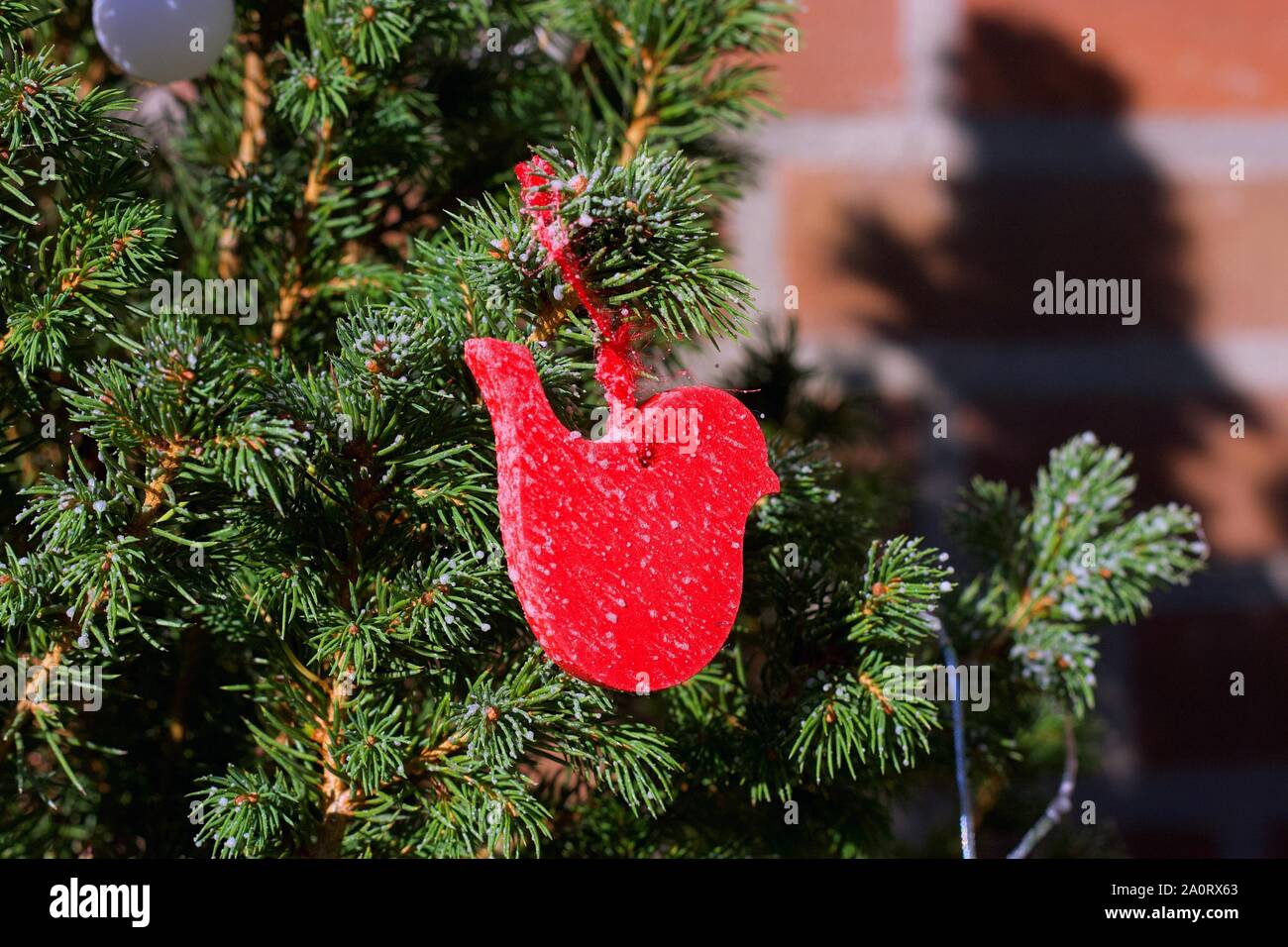 Weihnachtsbaum festliche rote Verzierungen in Form eines Vogels und Engel Stockfoto