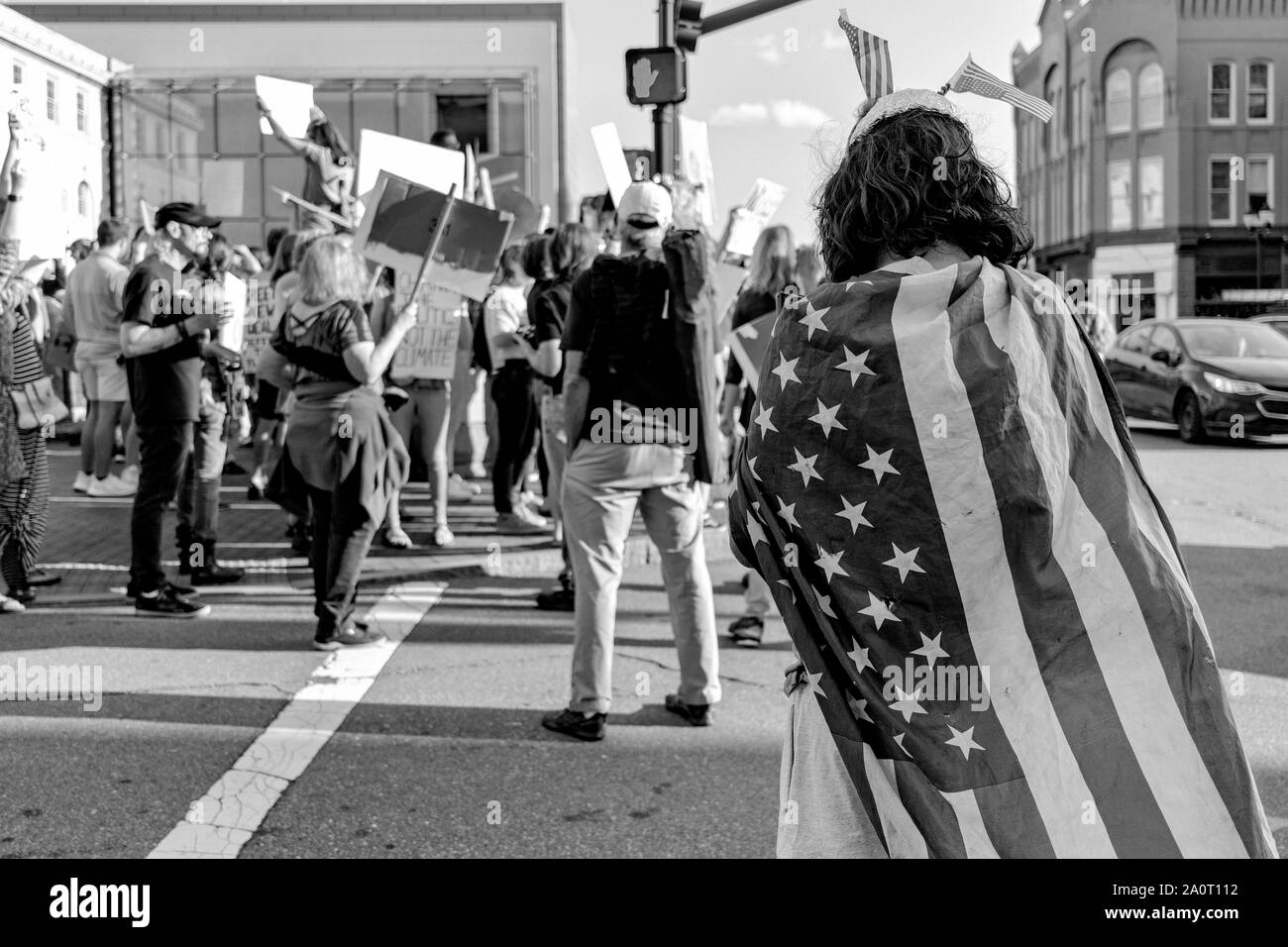 Ein Mann trägt eine amerikanische Flagge, die wie ein verwahrloster Super Hero, auf internationaler Klimagerechtigkeit Kundgebung in der Innenstadt von Asheville, NC, USA Stockfoto