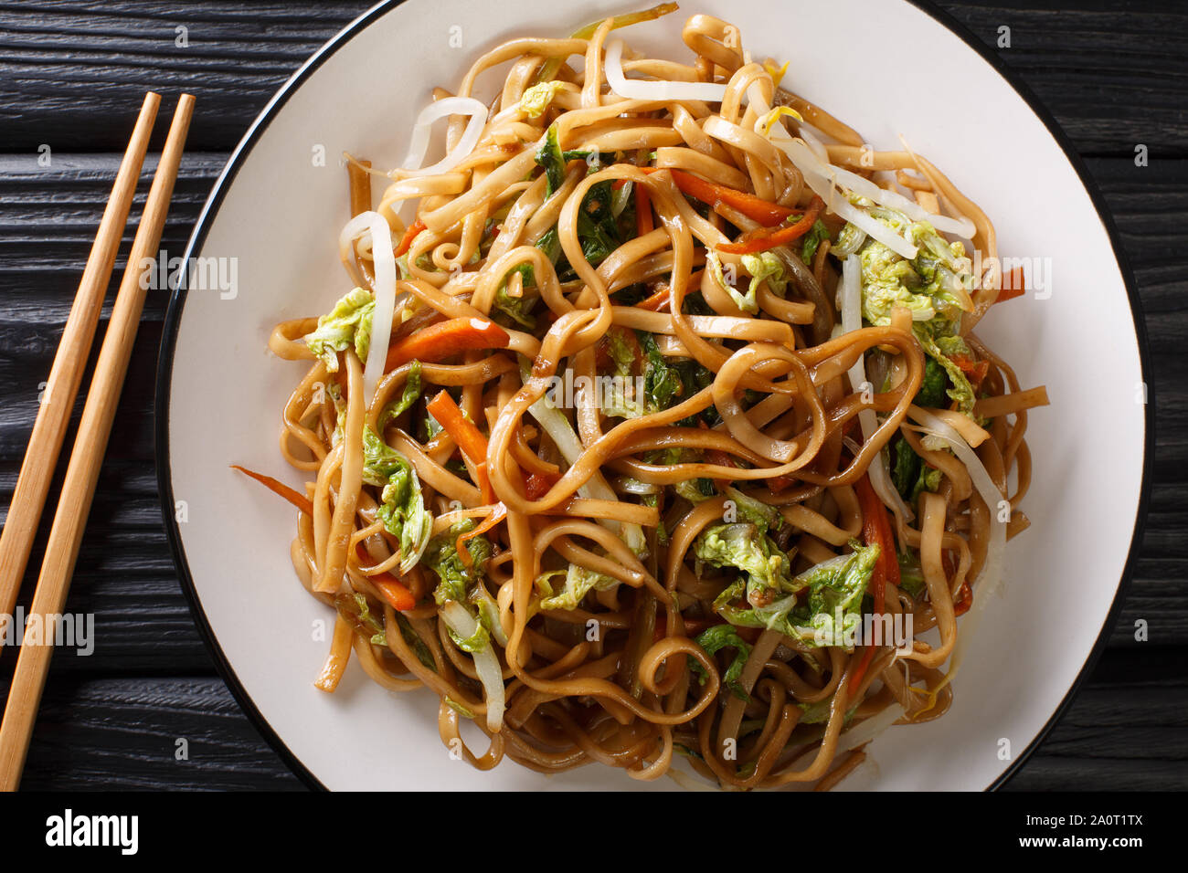 Vegetarisches Chow Mein Nudeln mit chinesischem Gemüse close-up auf einem Teller auf den Tisch. Horizontal oben Ansicht von oben Stockfoto