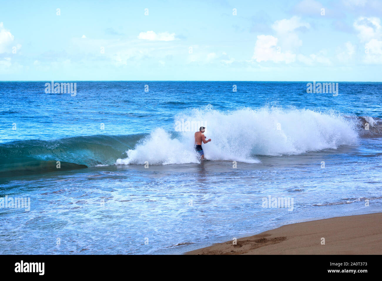 Sosua, Dominikanische Republik, 26. Dezember 2016, Mann im Meer am Strand und großen Ocean Wave mit Schaum und Spritzwasser an der Küste Stockfoto