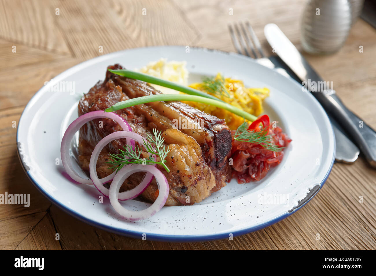 Gegrillte Rippchen mit Sauerkraut und Kartoffelpüree auf Tisch im Restaurant - herzhaftes Gericht Stockfoto