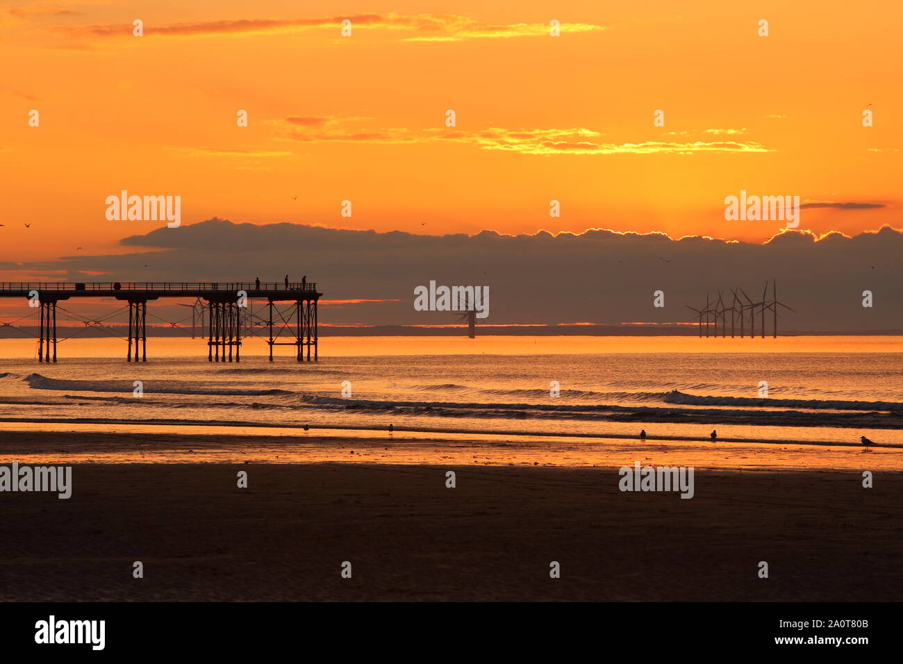 Sonnenuntergang an Saltburn Strand mit einer Silhouette einer Pier, North Yorkshire, England, Vereinigtes Königreich. Stockfoto
