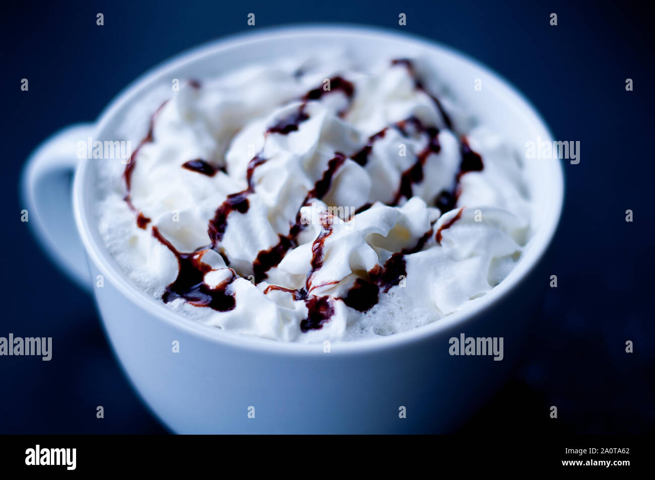 Tasse heißen Kakao oder mokka Kaffee closeup in einem großen weißen Schale verwischt. Frische Sahne beträufelt mit Schokolade Sirup und dunklen Hintergrund Detaillierte Stockfoto