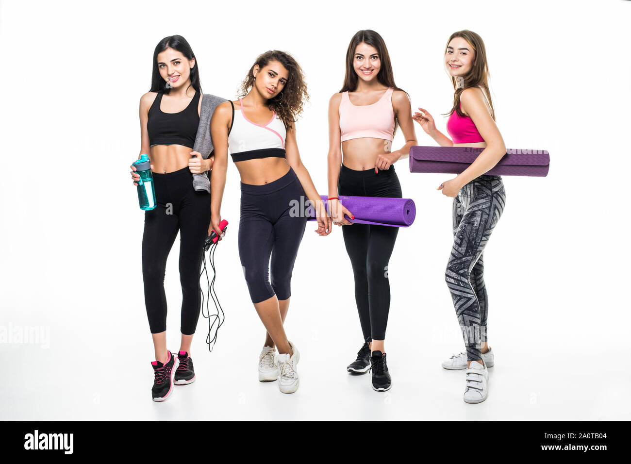 Vier Fitness Mädchen in Sportbekleidung sprechen auf weißem Hintergrund Stockfoto