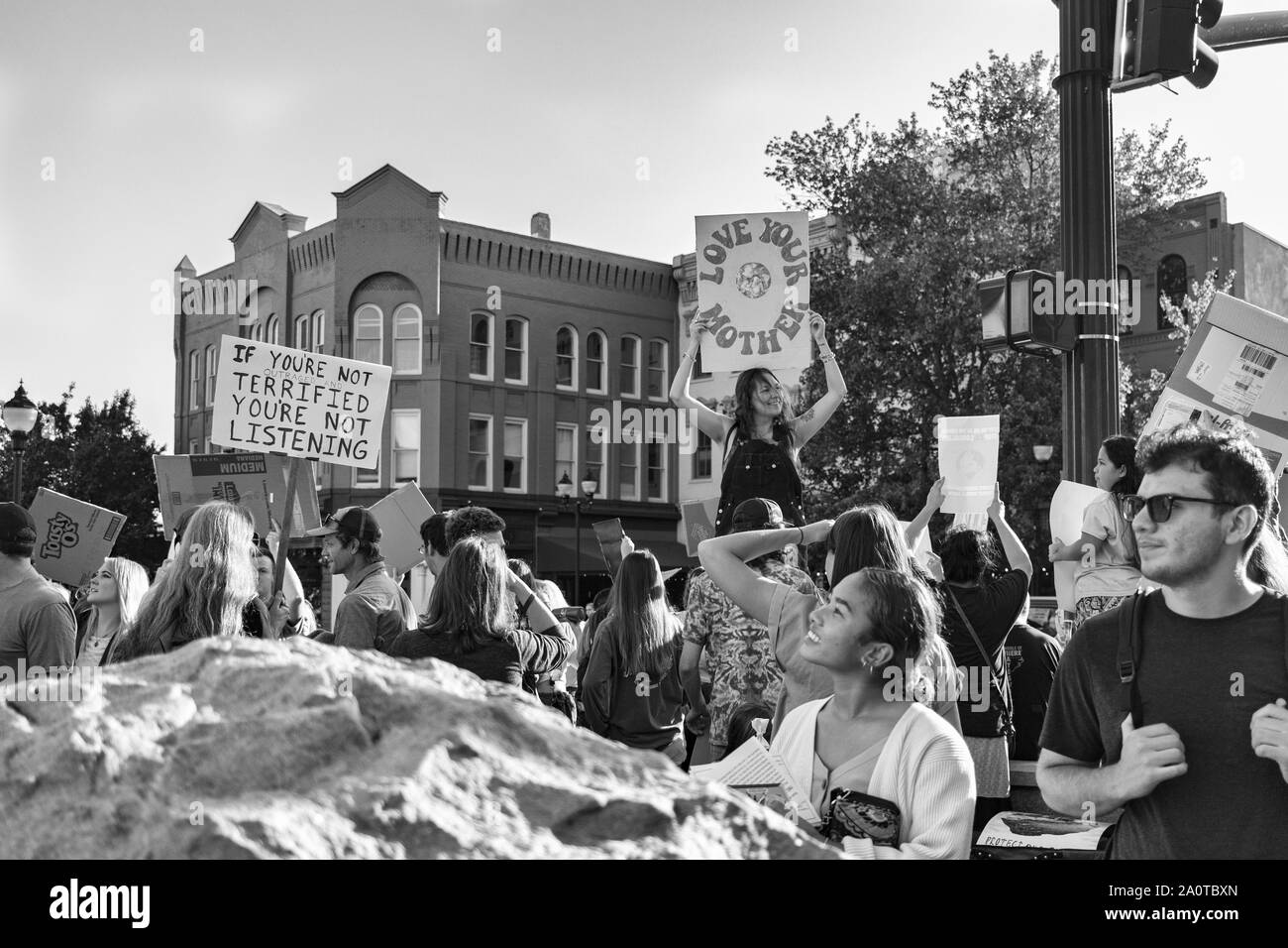 Eine Frau liest die Zeichen der Demonstranten auf internationaler Klimagerechtigkeit Rallye in Asheville, NC, USA Stockfoto