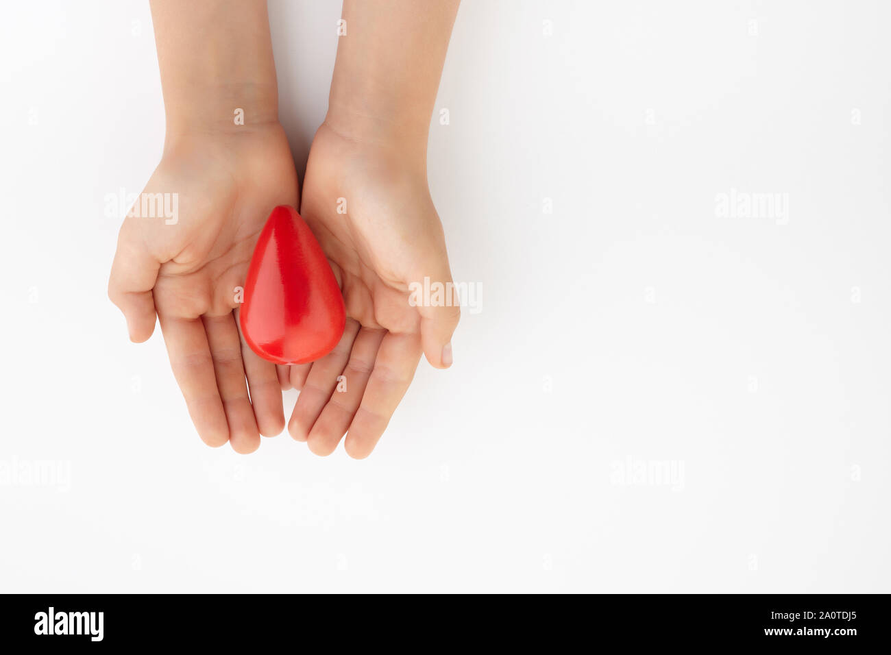Zwei Hände halten roten Blutstropfen auf weißem Hintergrund. Blut geben. Spende Konzept. Stockfoto