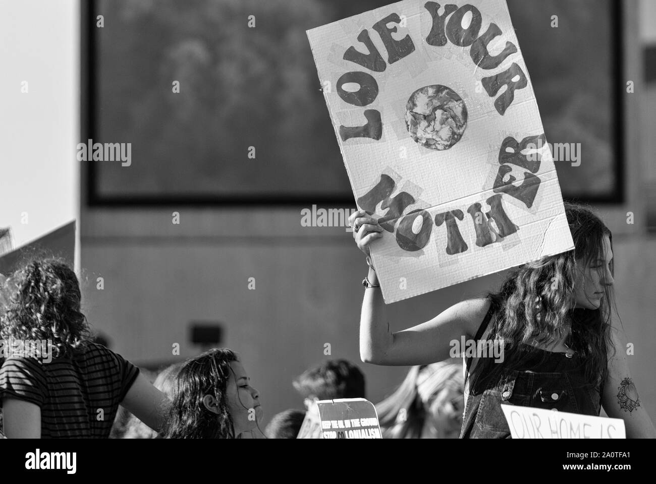 Ein tausendjähriges Mädchen hält ein Zeichen, das "Love Your Mother" bei der International Climate Justice Rally in Asheville, NC, USA sagt Stockfoto