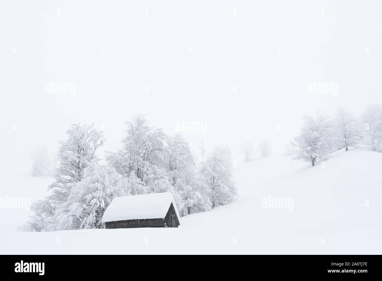 Winter Wonderland mit einer Holz- Haus in den Bergen. Snowy Christmas in einem Bergdorf. Hügel und Bäume im Schnee Stockfoto