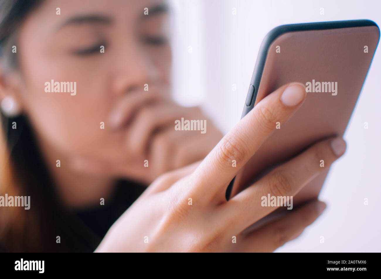 Ein depressiver junge Frau mit einem Mobiltelefon Stockfoto