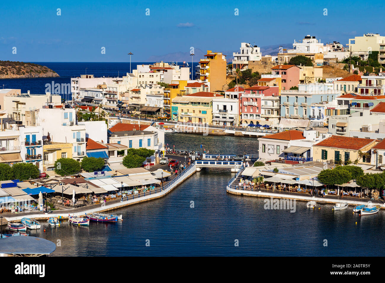 AGIOS NIKOLAOS, KRETA, GRIECHENLAND: 12. September 2019: See Voulismeni und verschiedenen bunten Gebäude in Agios Nikolaos bei Sonnenuntergang gesehen, Osten der Insel Kreta, Griechenland Stockfoto