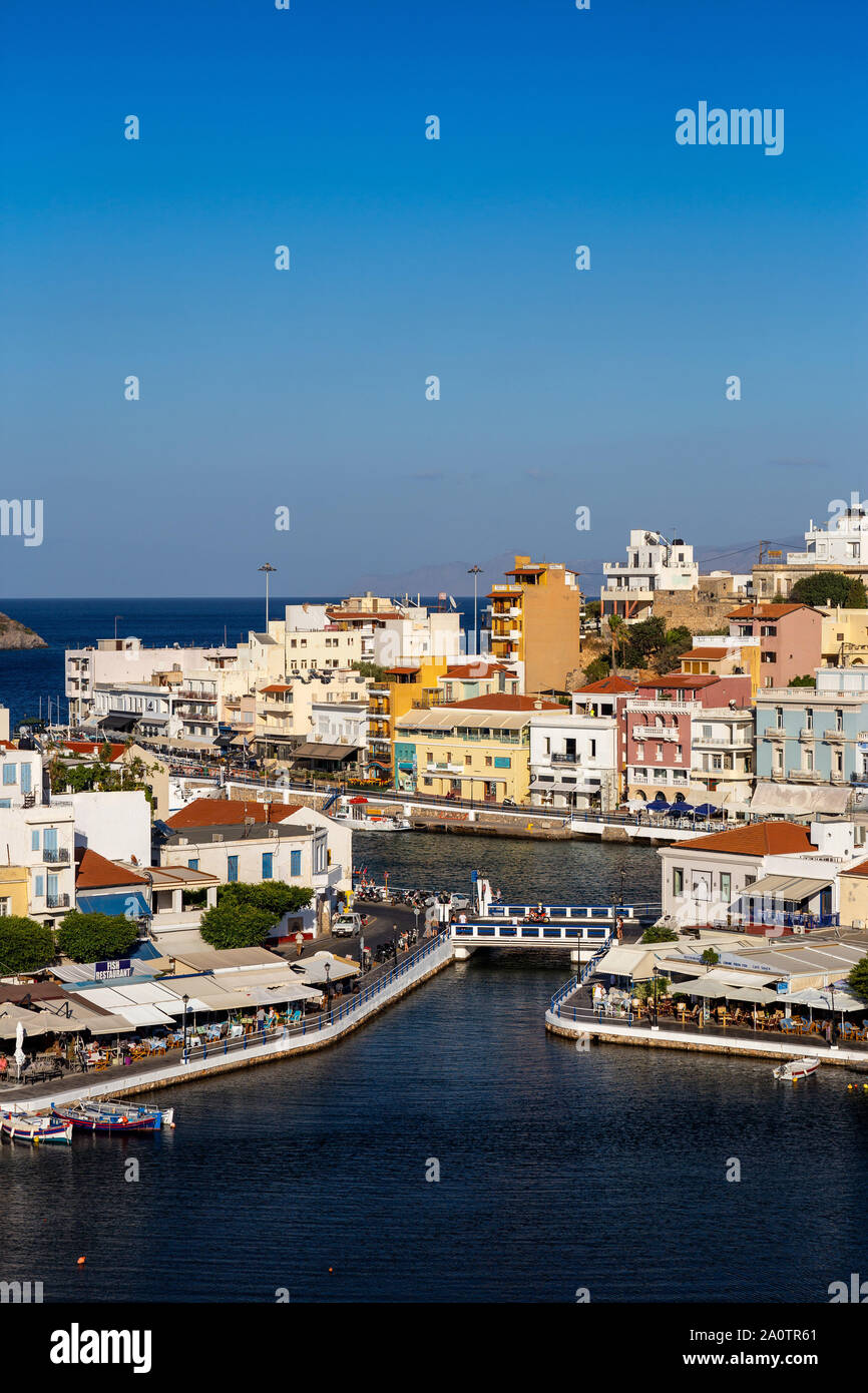AGIOS NIKOLAOS, KRETA, GRIECHENLAND: 12. September 2019: See Voulismeni und verschiedenen bunten Gebäude in Agios Nikolaos bei Sonnenuntergang gesehen, Osten der Insel Kreta, Griechenland Stockfoto