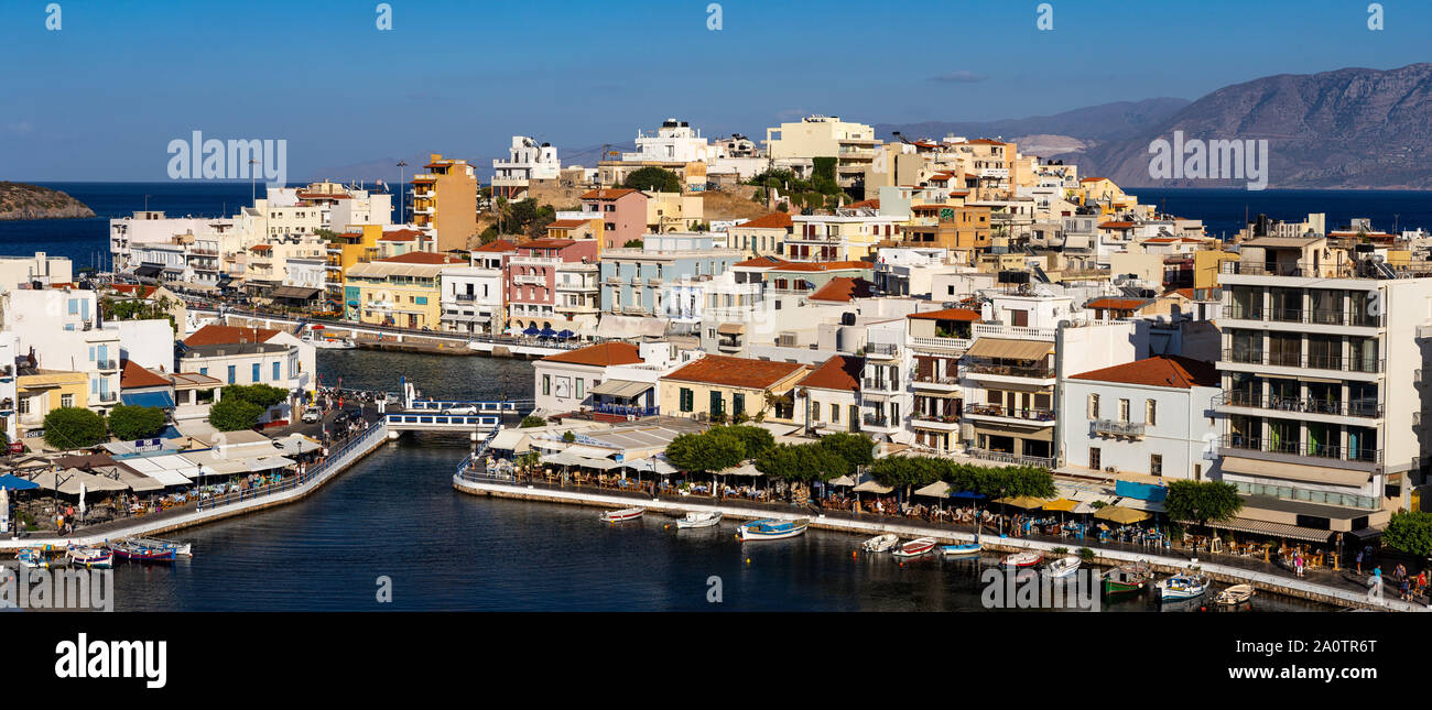 AGIOS NIKOLAOS, KRETA, GRIECHENLAND: 12. September 2019: See Voulismeni und verschiedenen bunten Gebäude in Agios Nikolaos bei Sonnenuntergang gesehen, Osten der Insel Kreta, Griechenland Stockfoto