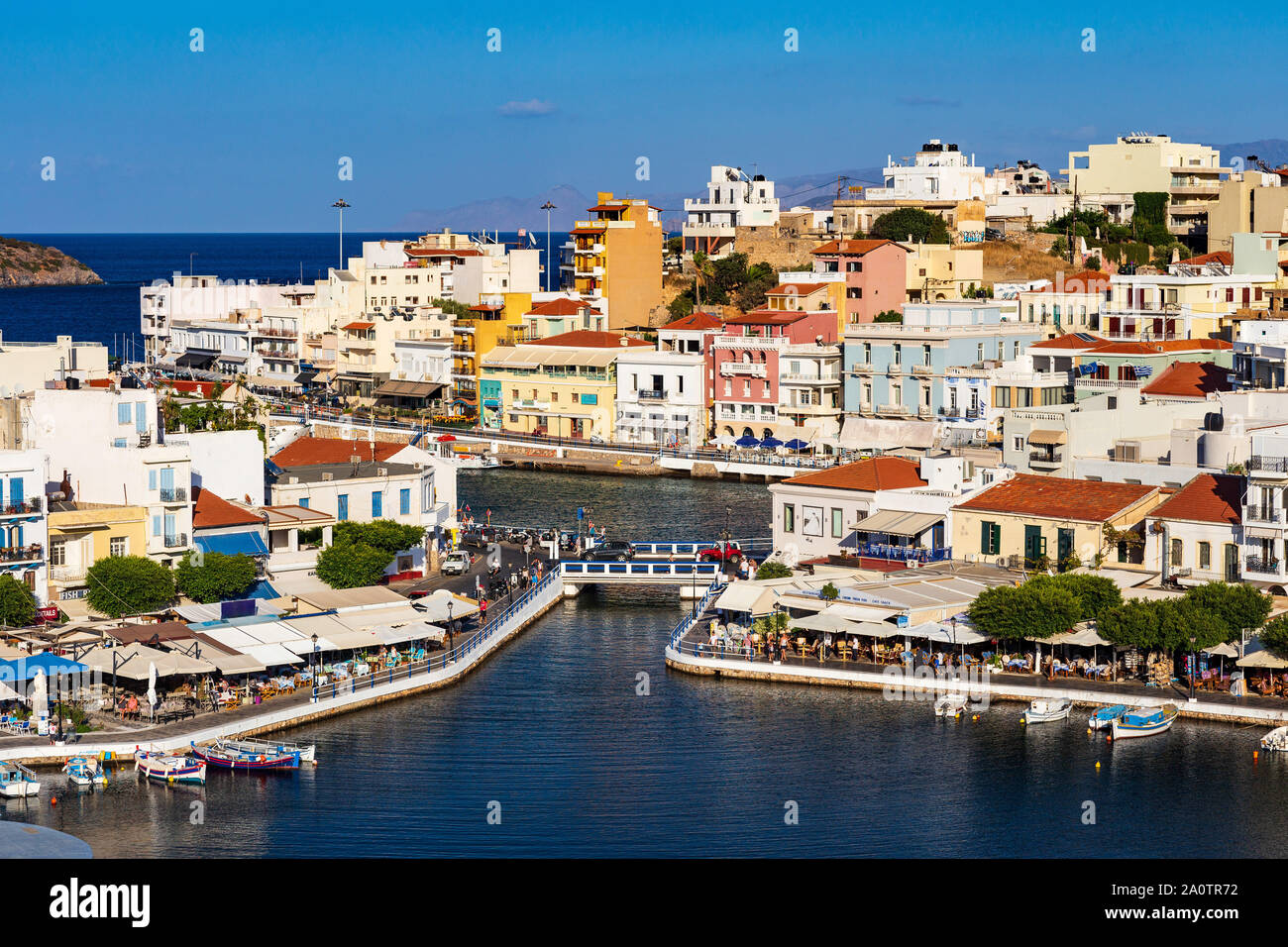 AGIOS NIKOLAOS, KRETA, GRIECHENLAND: 12. September 2019: See Voulismeni und verschiedenen bunten Gebäude in Agios Nikolaos bei Sonnenuntergang gesehen, Osten der Insel Kreta, Griechenland Stockfoto