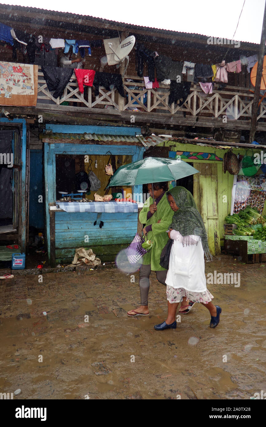 Zwei Frauen teilen ein Regenschirm in den Regen, Andasibe, Madagaskar. Keine MR oder PR Stockfoto