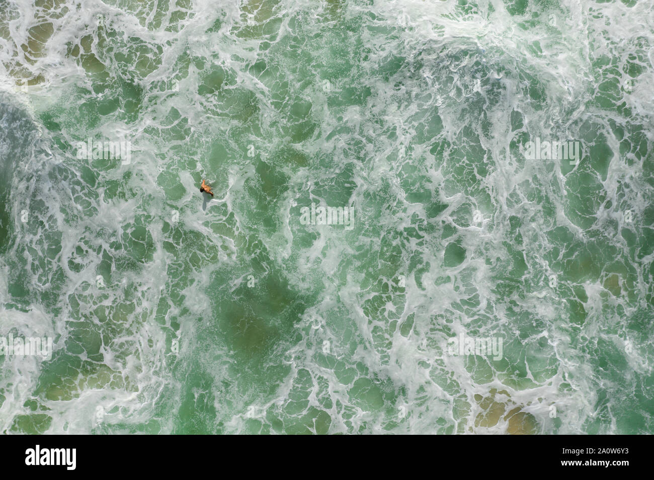 Gerade nach unten geschossen von Mann Schwimmen im brechenden Wellen mit wite überall Wasser. Stockfoto