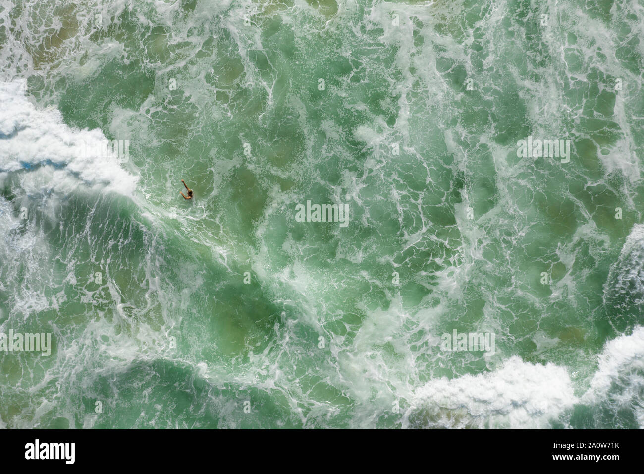 Gerade nach unten geschossen von Mann Schwimmen im brechenden Wellen mit wite überall Wasser. Stockfoto