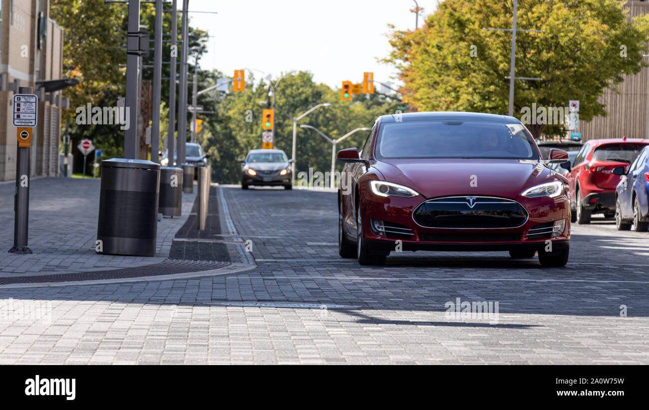 Tesla Model S im Schatten an einem sonnigen Tag auf einem brick road in den Städten London, Ontario gesehen. Stockfoto