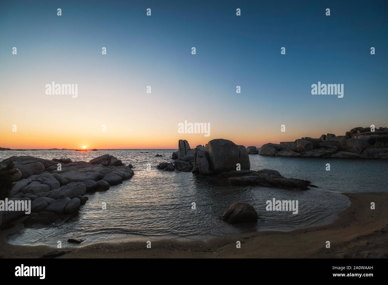 Breaking Dawn über Geröll am Strand auf Cavallo Insel im Lagoon Archipel südlich von Korsika in Frankreich Stockfoto