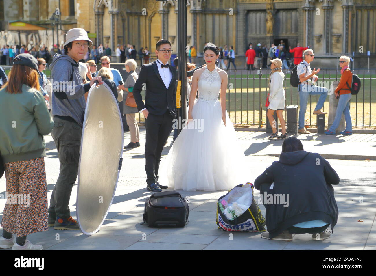 Eine chinesische Braut und Bräutigam erhalten ihre Fotos Hochzeit vor der Westminster Abbey, London, Großbritannien Stockfoto