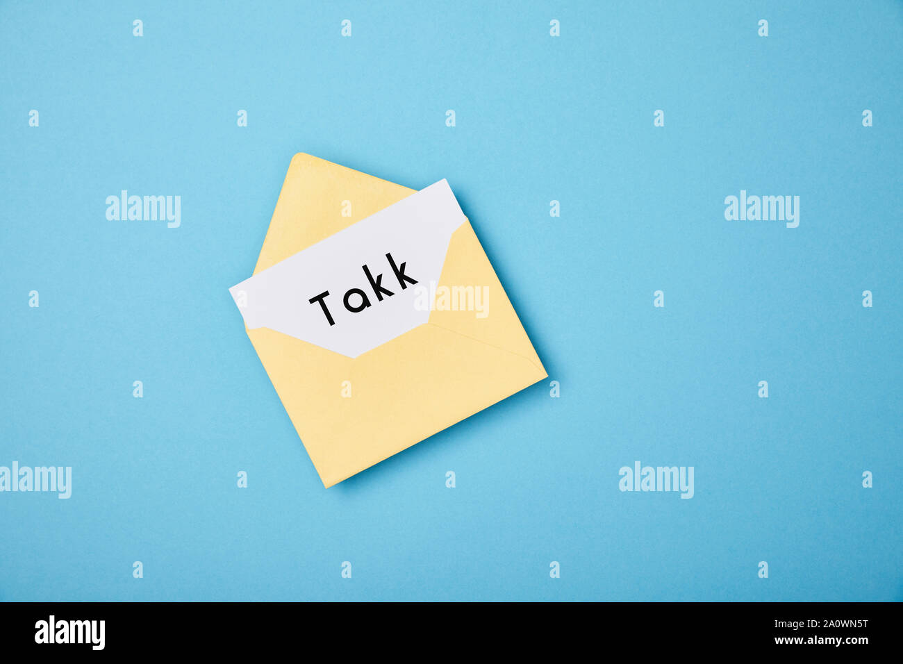 Gelber Umschlag Und Weisse Karte Mit Takk Wort Auf Blauem Hintergrund Stockfotografie Alamy