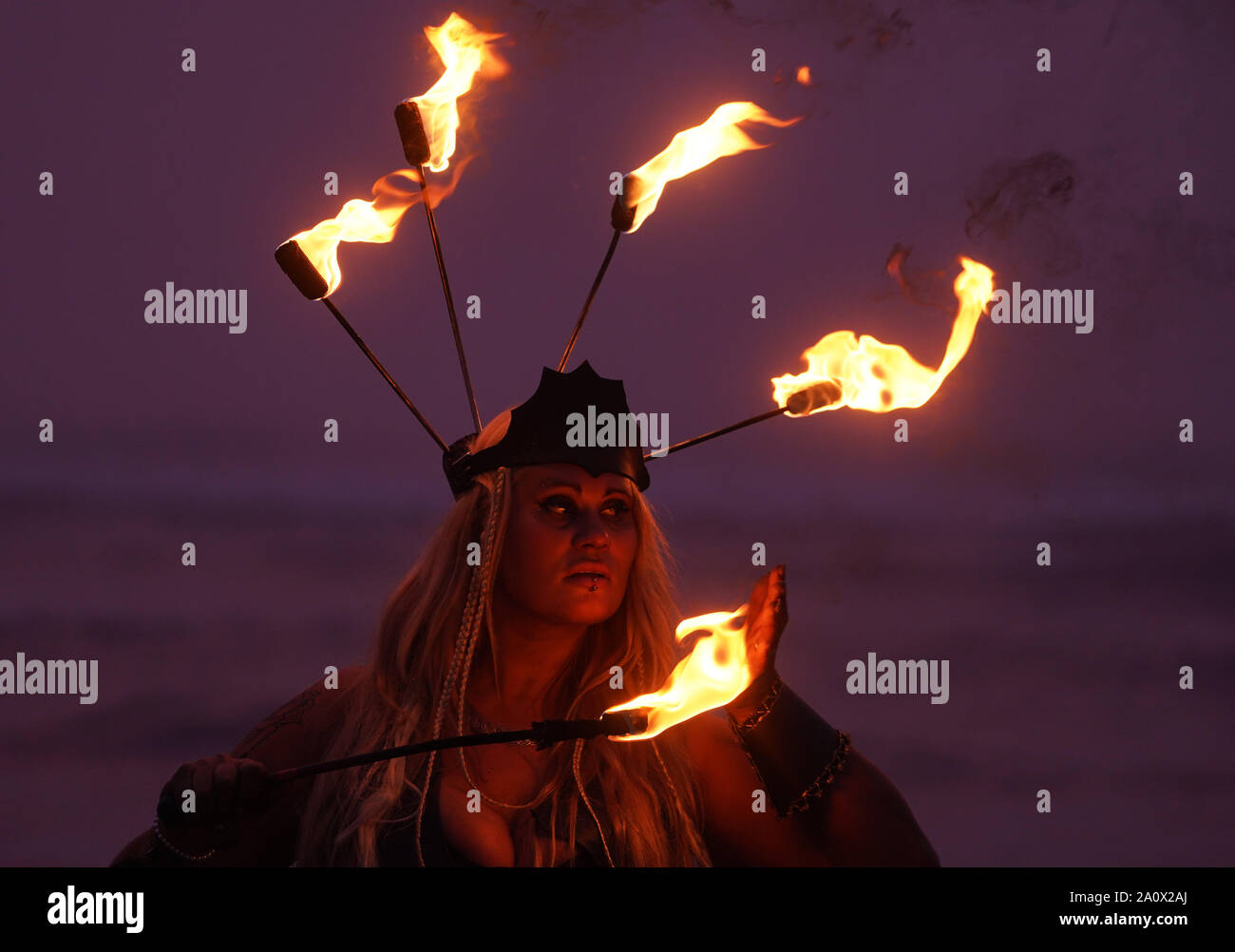 Feuer interpret Penella Biene führt, bevor die Menschen Teil im Norden Osten Skinny Dip an druridge Bay in Nothumberland, eine jährliche Veranstaltung, die Herbst-tagundnachtgleiche Marken und hebt Geld für die Mentale Gesundheit Nächstenliebe. Stockfoto