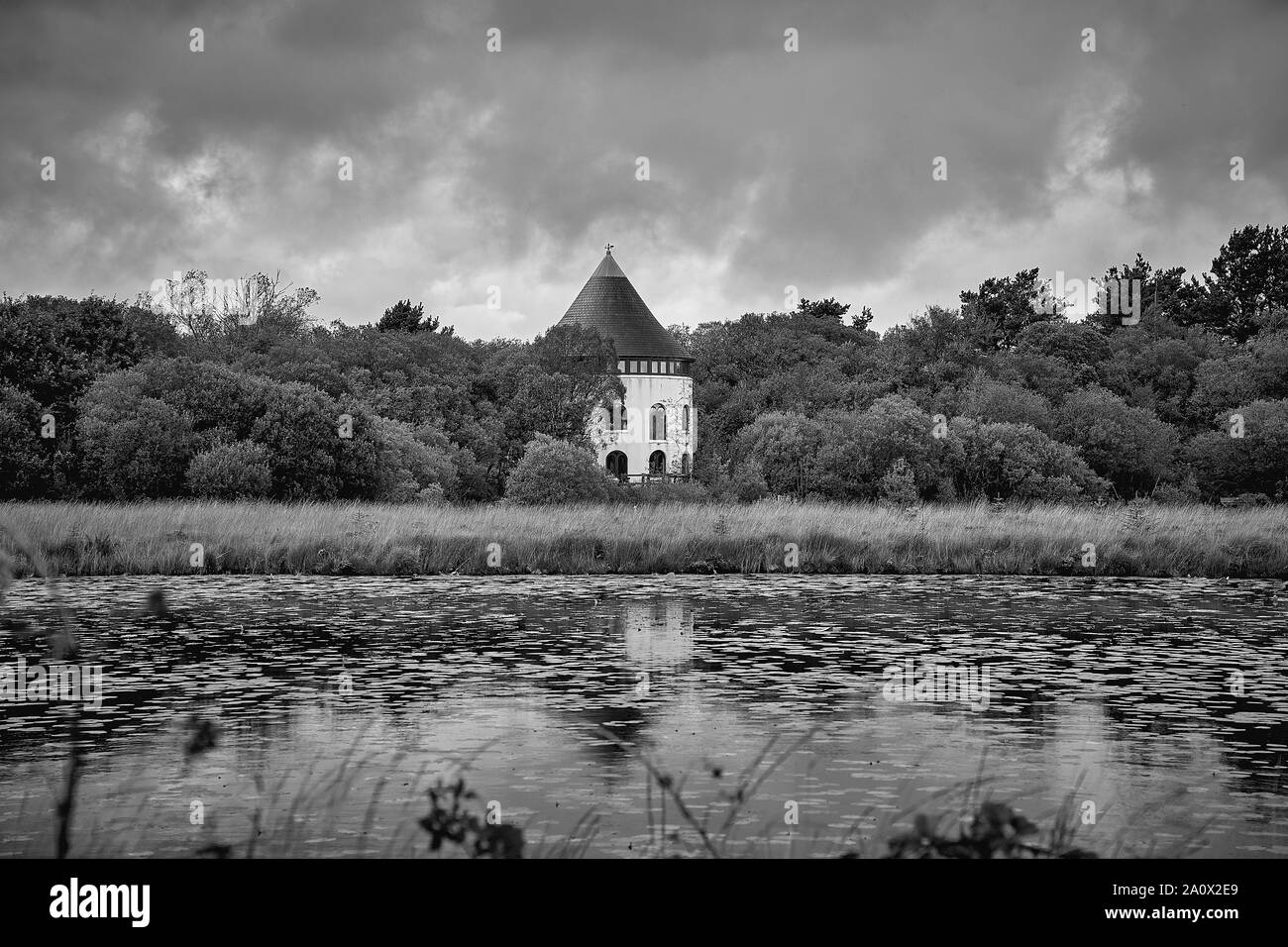 Blick über einen See von einem runden Haus im Wald eingebettet Stockfoto