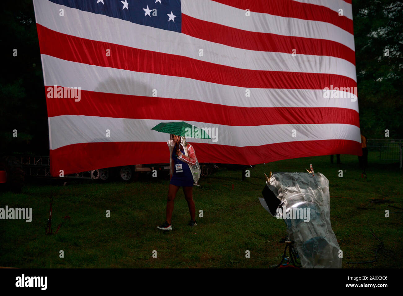 Des Moines, USA. 21 Sep, 2019. Eine Frau geht Vergangenheit eine amerikanische Flagge während der Polk County Steak braten am Wasser funktioniert Park in Des Moines, Iowa. Das Event zog in der 17 Kandidaten für die demokratische Nominierung für das Amt des Präsidenten der Vereinigten Staaten. Die Iowa Kaukasus sind Montag, 3. Februar 2020 und obwohl keine primäre wird schmaler hinunter das Feld der Kandidaten für das Amt des Präsidenten, bevor die erste Wahl im Bundesstaat New Hampshire. Credit: SOPA Images Limited/Alamy leben Nachrichten Stockfoto