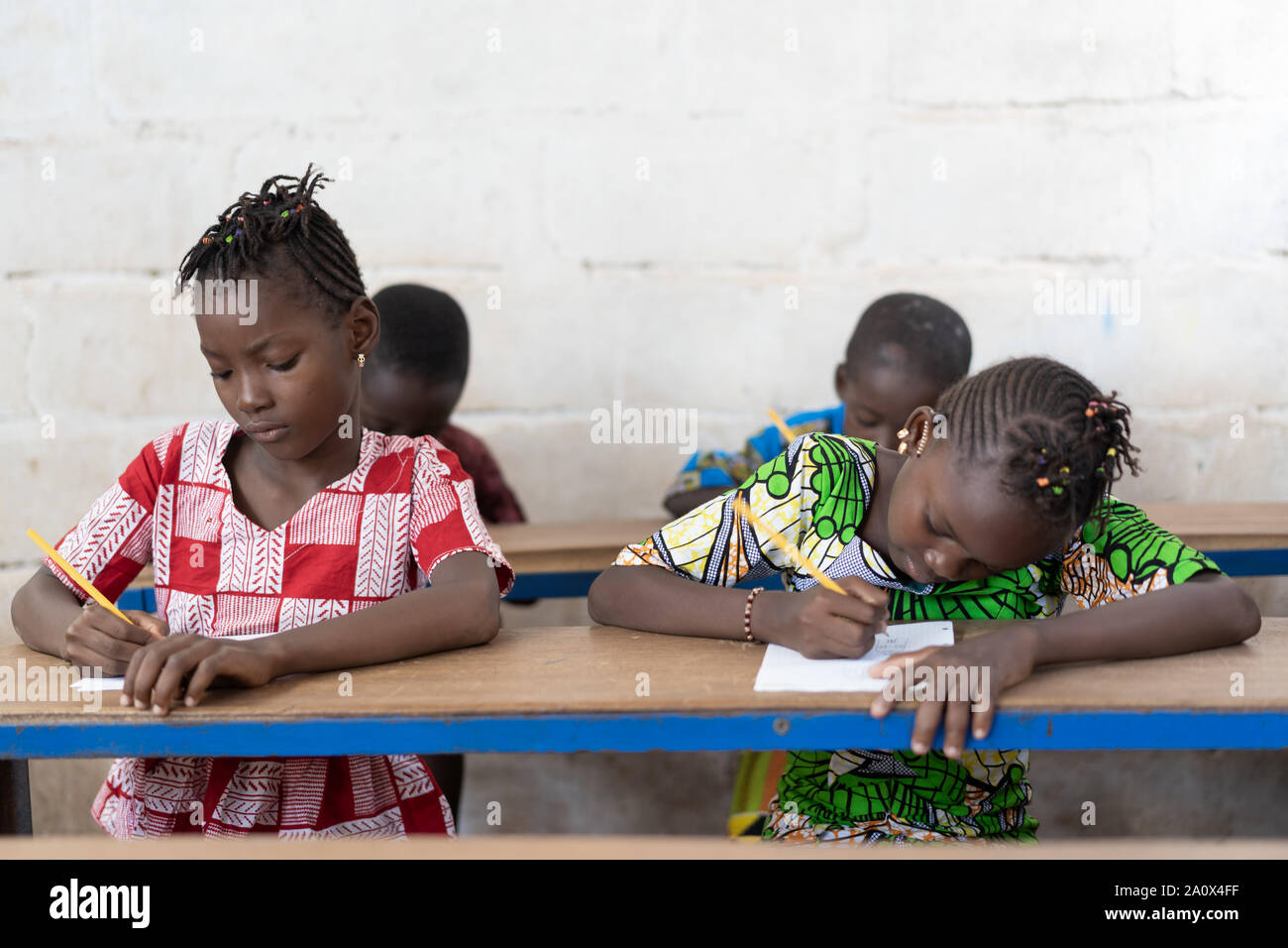 Vier wunderschöne afrikanischen schwarzen Kinder sitzen in Schreibtische Stockfoto