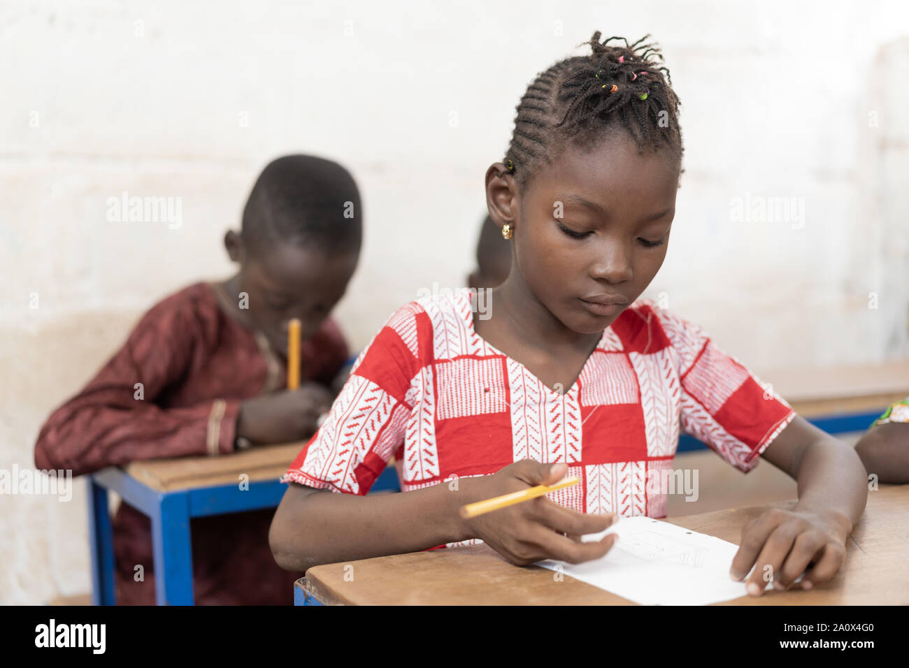 Wunderschöne Afrikanische Mädchen sitzen in ihrem Schreibtisch arbeiten Lernen Stockfoto