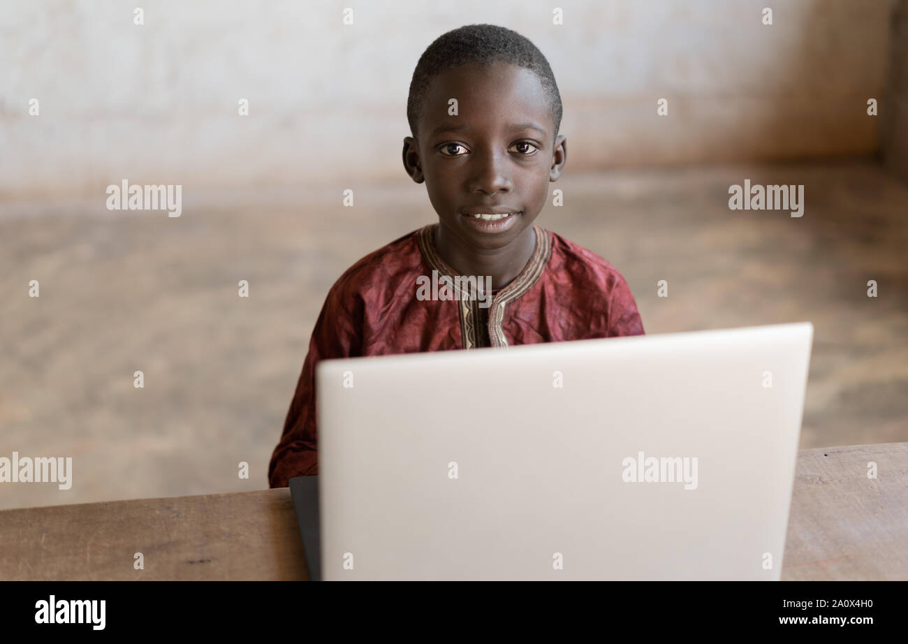 Wunderschönen afrikanischen Jungen Portraitfotos Heads Up mit Laptop Stockfoto