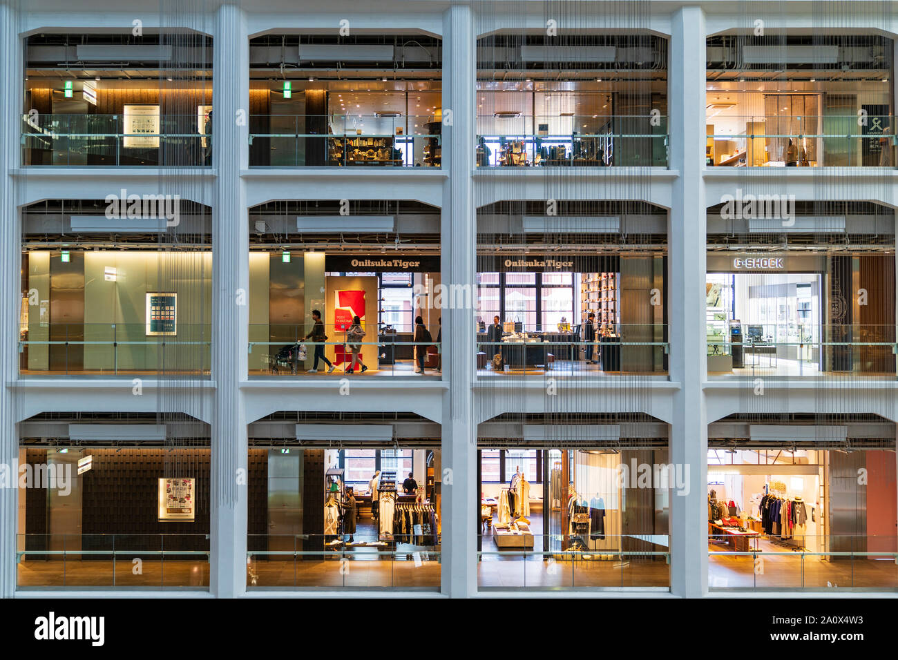 Tokio, Marunouchi. JP Turm KITTE Gebäude Interieur. Drei Etagen mit jeweils vier offenen Geschäften auf der einen Seite der dreieckigen Atrium. Onitsuka Tiger zu speichern. Stockfoto