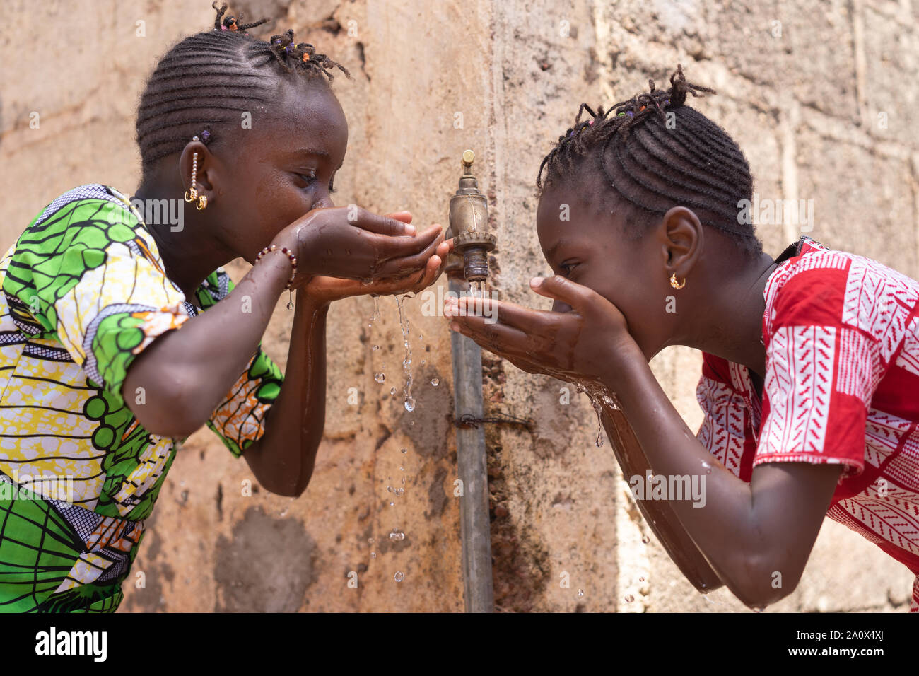 Frisches Wasser bedeutet Leben für Afrikanischen schwarzen Kinder Stockfoto