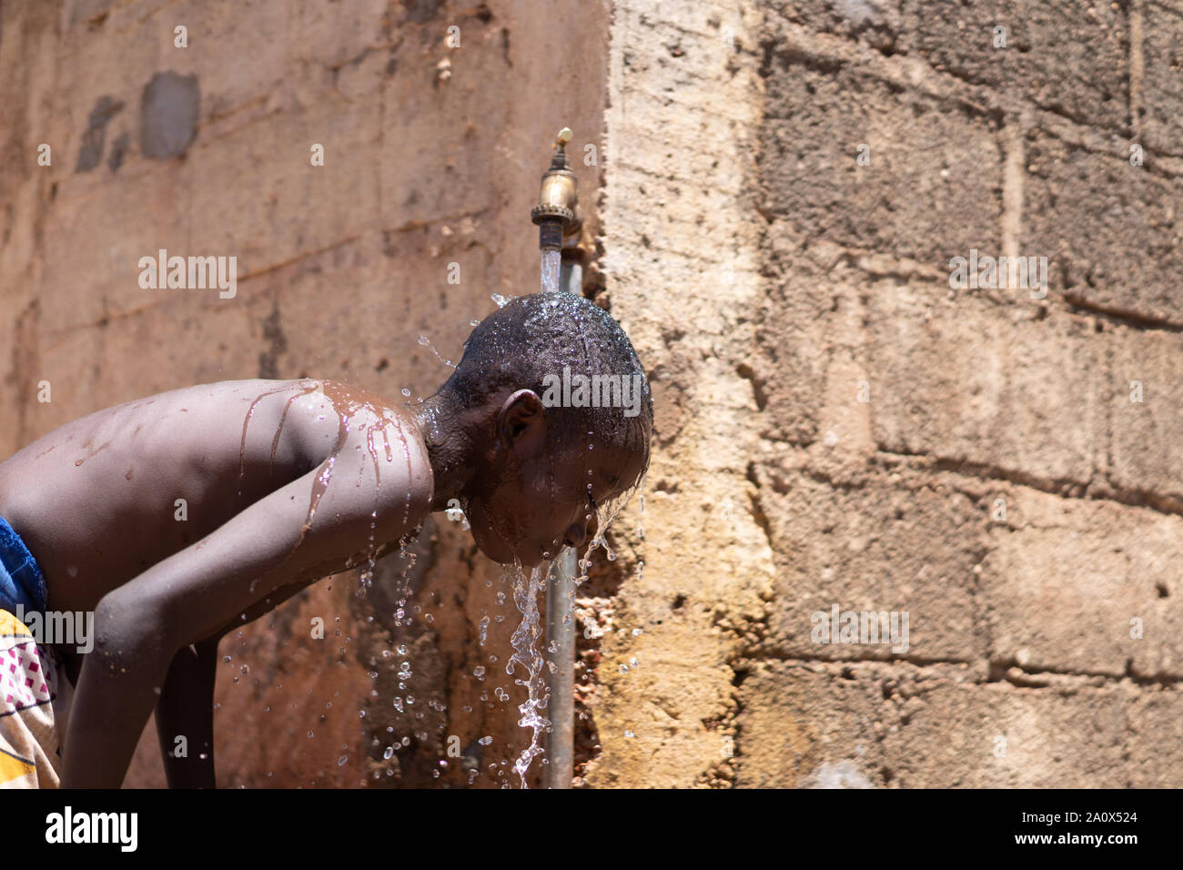 Hygiene Symbol, afrikanischen schwarzen Jungen waschen unter Tippen Stockfoto