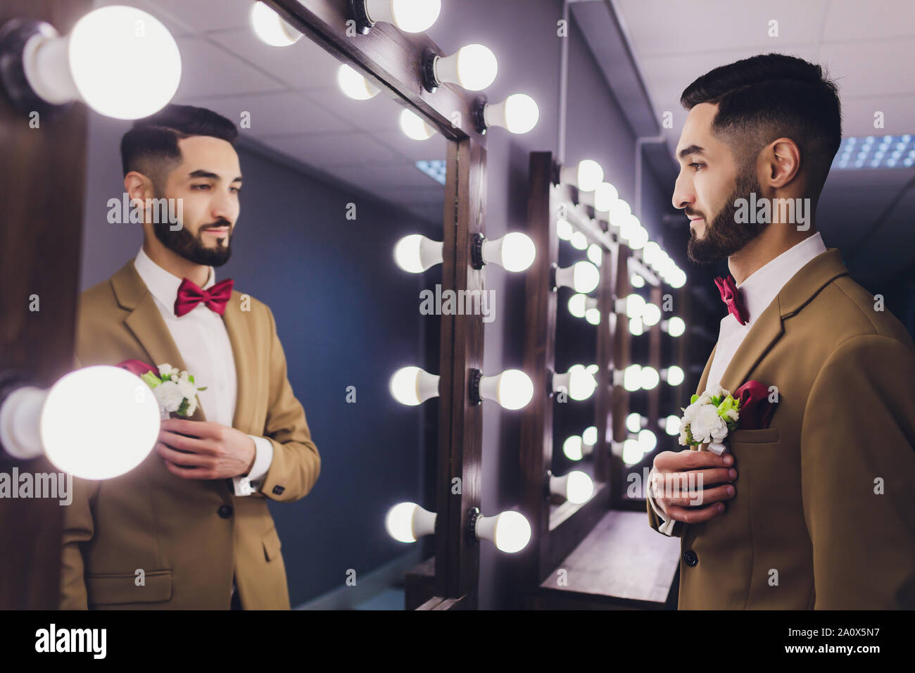 Schöne starke stilvolle bärtigen Bräutigam in der Nähe von Spiegel posieren. Stockfoto