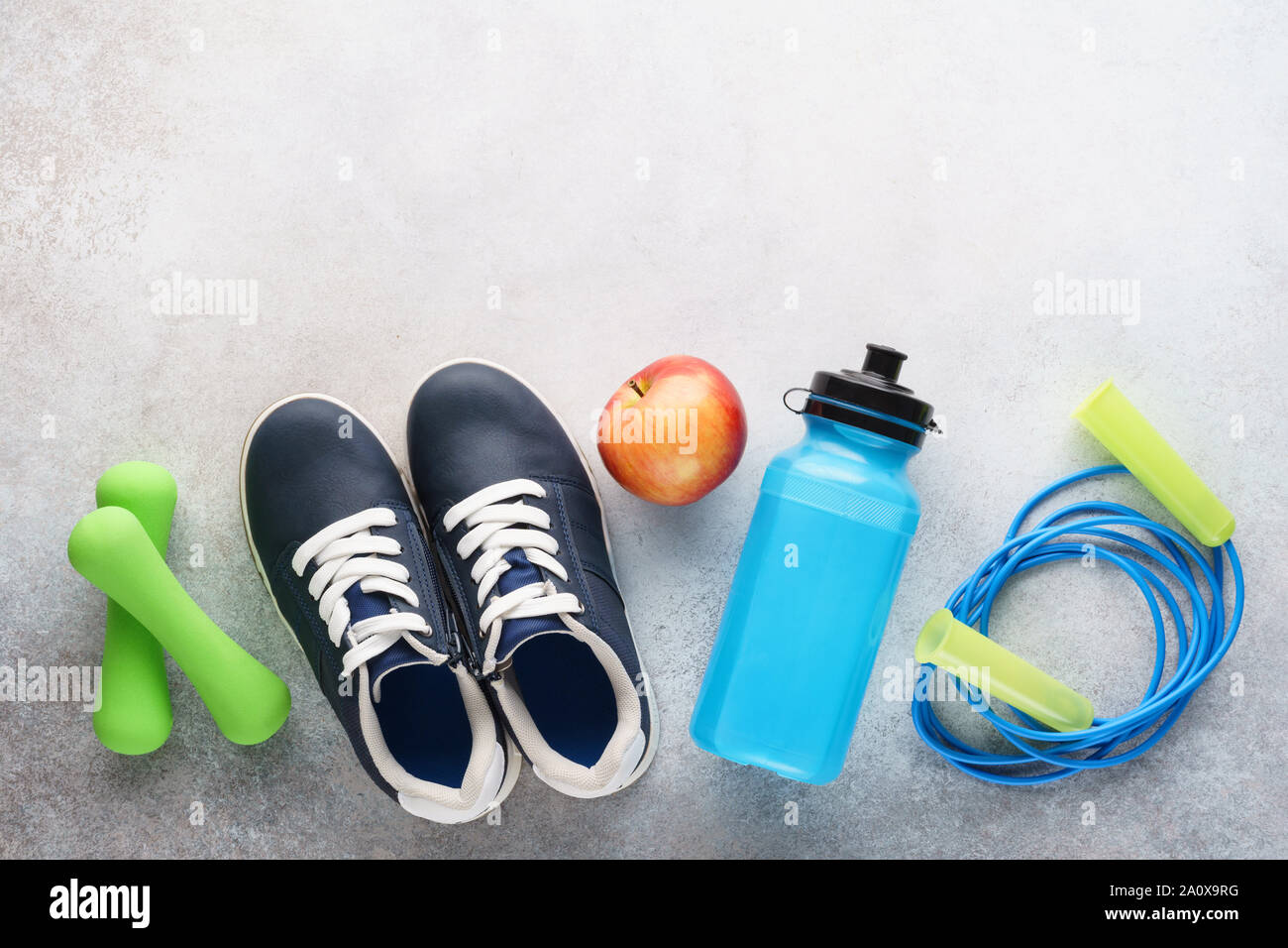 Fitness Hintergrund mit Turnschuhen, Wasserflasche, Hanteln und Springseil. Sport Equipment. Gesunder Lebensstil Konzept. Kopieren Sie Platz. Stockfoto