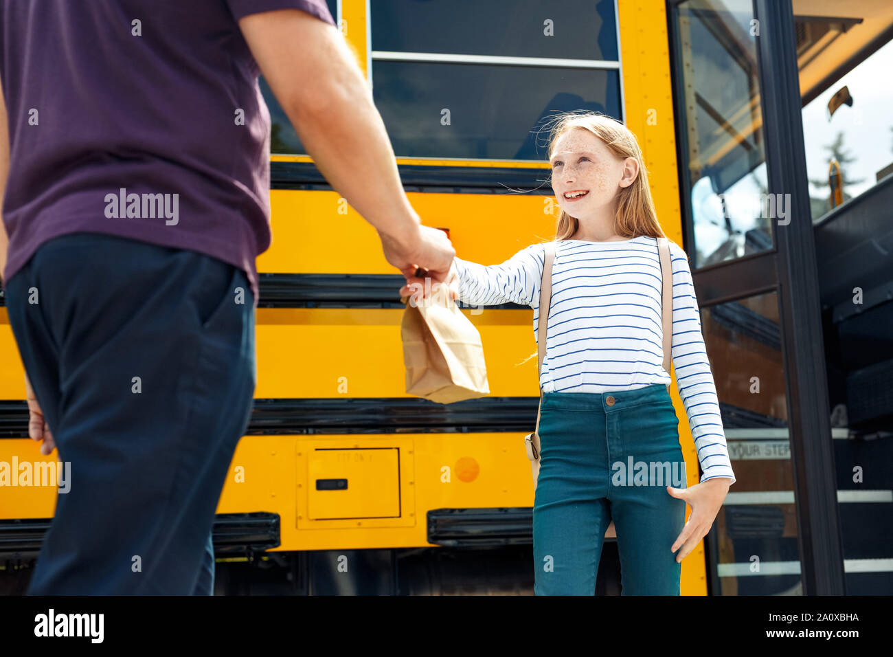 Vater Lunch Bag zu den glücklichen Tochter zur Schule mit dem Bus close-up Stockfoto