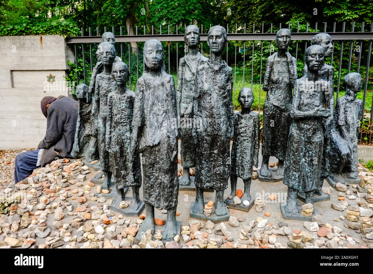 18 Juli 2019, Berlin: Ein alter Mann sitzt am Rand einer Gruppe von Figuren vom Bildhauer Willi Lambert Vor einem jüdischen Friedhof Große Hamburger Straße im Berliner Bezirk Mitte. Ist das erste Altersheim der Jüdischen Gemeinde von Berlin, im Jahre 1828 erbaut wurde, wurde hier entfernt. Es wurde von den Nationalsozialisten 1942 in ein Sammellager für jüdische Bürger umgewandelt, von denen 55.000 Juden in die nationalsozialistischen Konzentrationslager zusammengepfercht waren, bevor sie deportiert und ermordet. Foto: Stefan Jaitner/dpa Stockfoto