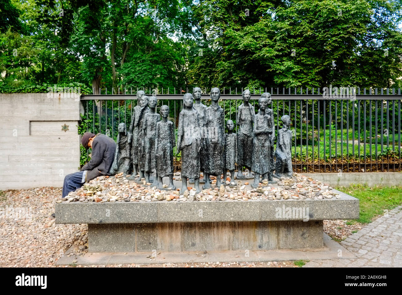 18 Juli 2019, Berlin: Ein alter Mann sitzt am Rand einer Gruppe von Figuren vom Bildhauer Willi Lambert Vor einem jüdischen Friedhof Große Hamburger Straße im Berliner Bezirk Mitte. Ist das erste Altersheim der Jüdischen Gemeinde von Berlin, im Jahre 1828 erbaut wurde, wurde hier entfernt. Es wurde von den Nationalsozialisten 1942 in ein Sammellager für jüdische Bürger umgewandelt, von denen 55.000 Juden in die nationalsozialistischen Konzentrationslager zusammengepfercht waren, bevor sie deportiert und ermordet. Foto: Stefan Jaitner/dpa Stockfoto