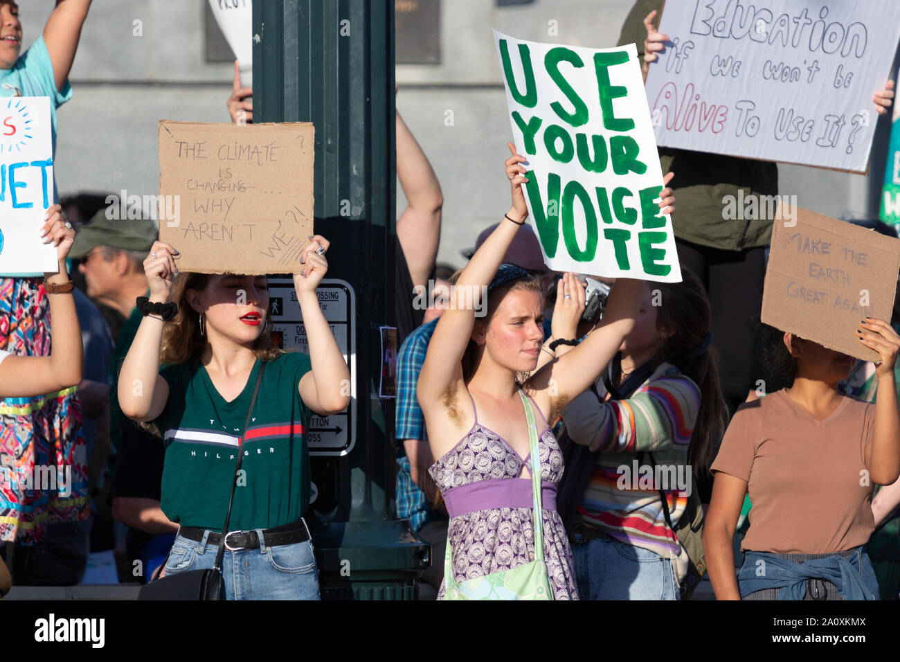 Die Demonstranten halten Schilder auf vorbeifahrende Autos auf internationaler Klimagerechtigkeit Rallye in Asheville, NC, USA. Stockfoto