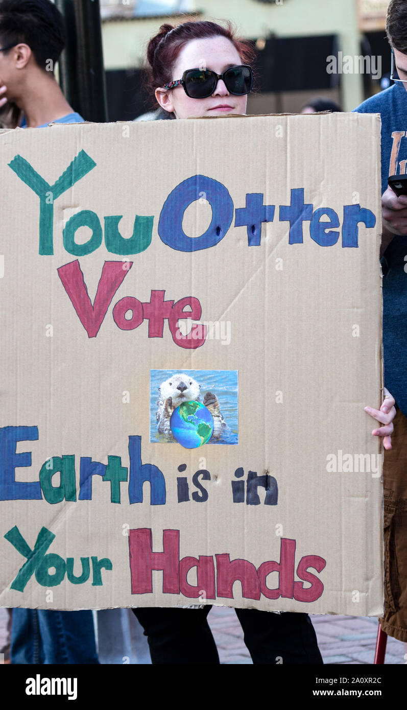 Eine Frau hält ein Schild mit der Aufschrift "You Otter Vote, The Earth is in Your Hand" bei der Internationalen Climate Justice Rallye in Asheville, NC, USA. Stockfoto