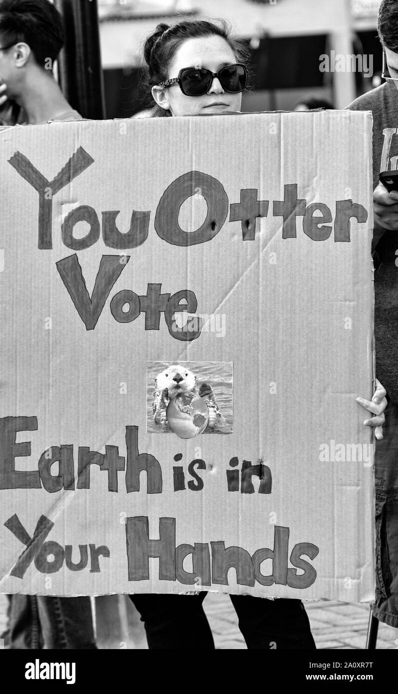 Eine Frau hält ein Schild mit der Aufschrift "You Otter Vote, The Earth is in Your Hand" bei der Internationalen Climate Justice Rallye in Asheville, NC, USA. Stockfoto