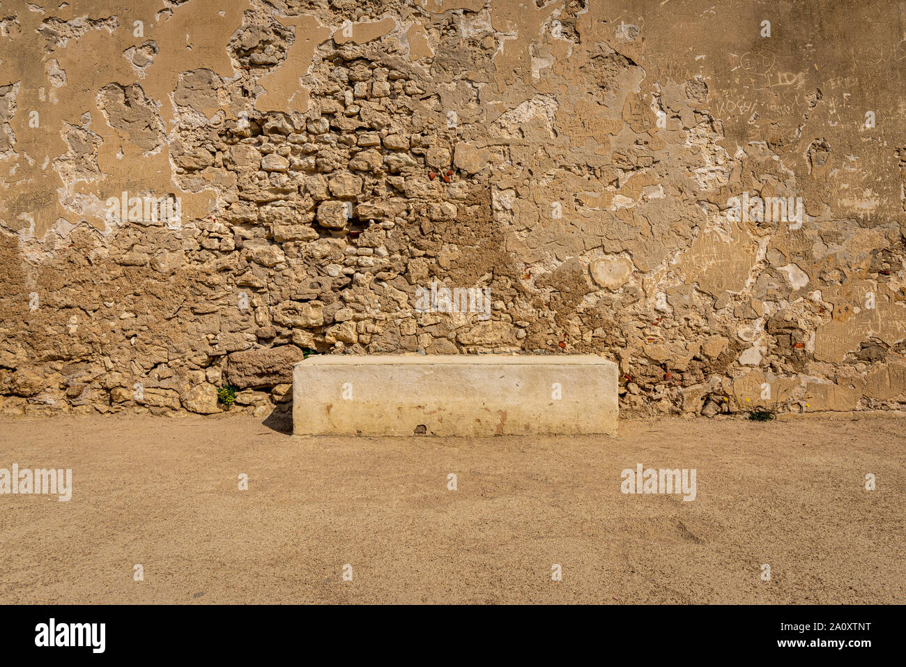 Konkrete Bank gegen verwitterten Stein und crepis Wand. An einem Sommernachmittag, Bonifacio, Frankreich genommen Stockfoto