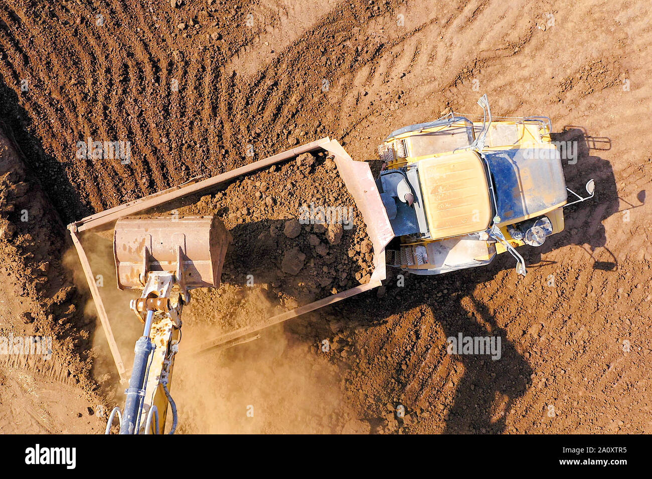 Bagger laden Boden auf einer Artikulierten hauler Truck, Top-down-Antenne Stockfoto