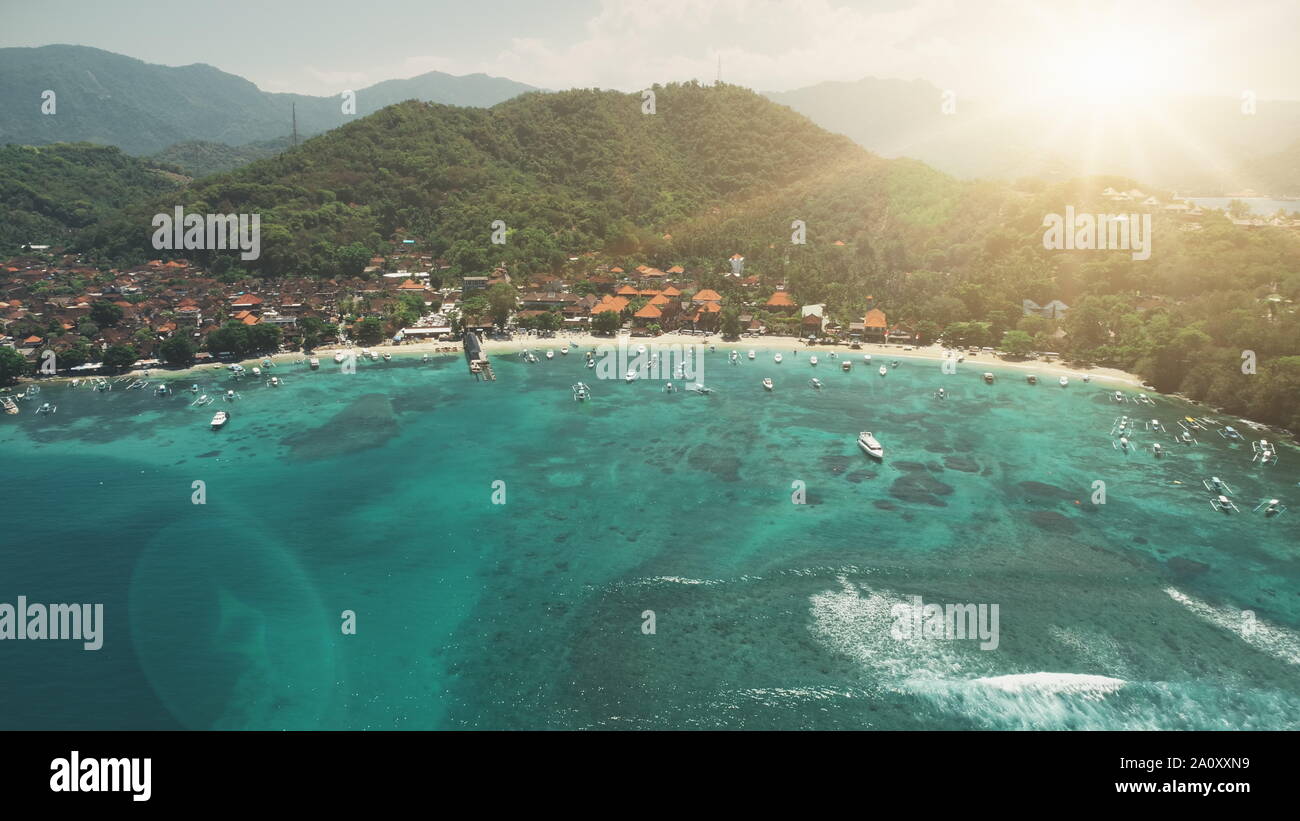 Luftaufnahme Crystal Ocean Harbour Bay, weißer Strand und grünen Wald Berge im Sonnenuntergang weiches Licht. Reise Urlaub Paradies Tourismus Konzept. Exotische Natur Landschaft. Die Insel Bali, Indonesien Stockfoto