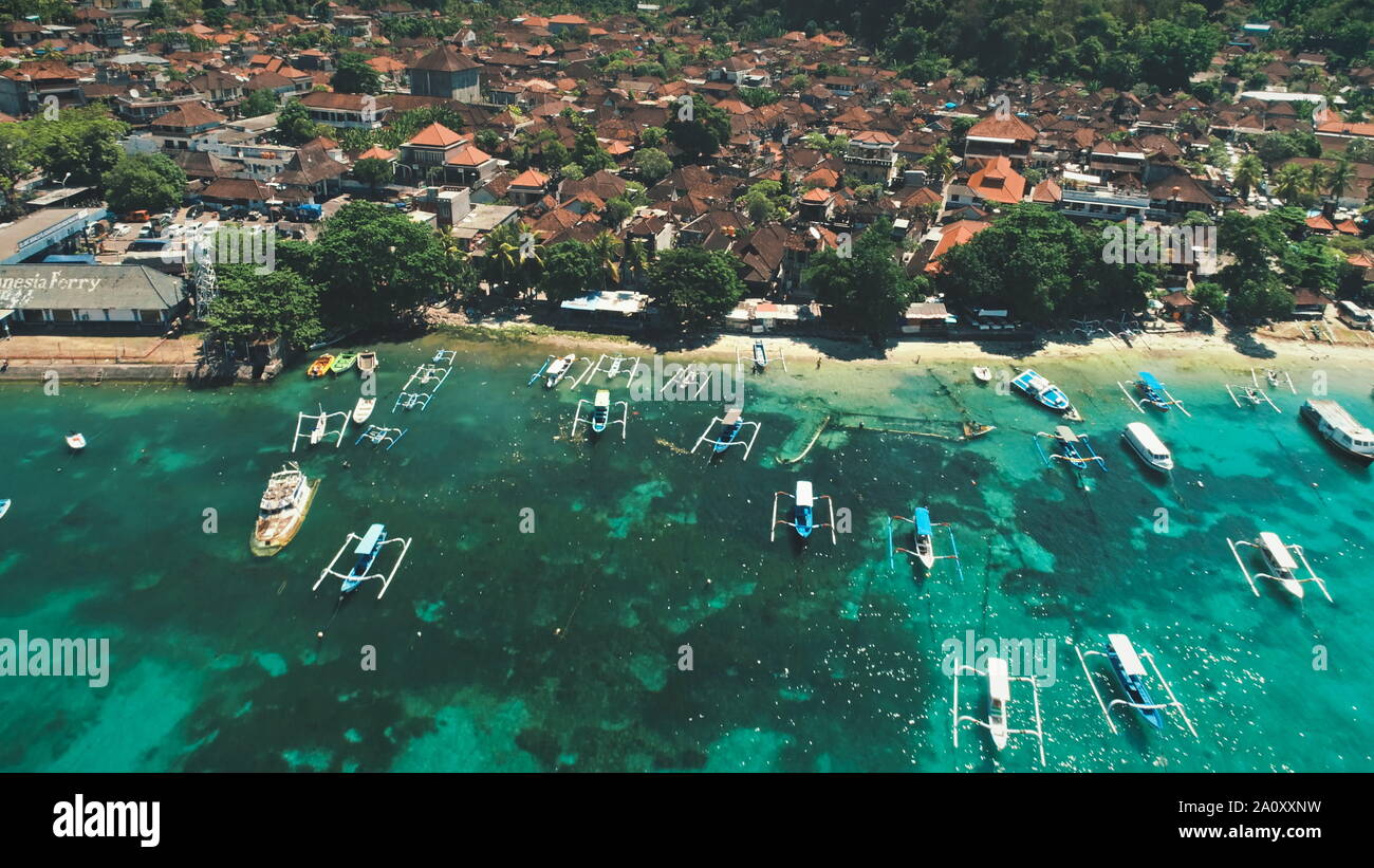 Antenne Flug über Crystal Ocean Harbour, Fischerboote, Dorf Dächer und grünen Wald Berge. Reisen Urlaub Tourismus. Exotische Natur Landschaft. Die Insel Bali, Indonesien Stockfoto