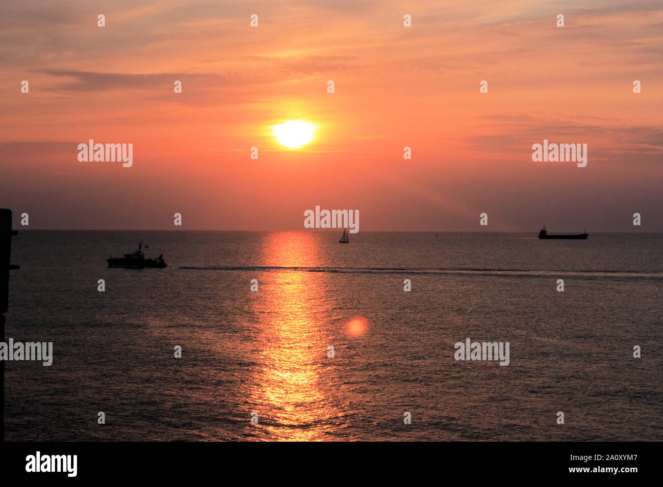 Genießen Sie einen fantastischen Sonnenuntergang mit einem orangefarbenen bewölkter Himmel am Strand von Scheveningen, Den Haag, Niederlande, an einem Sommerabend. Stockfoto